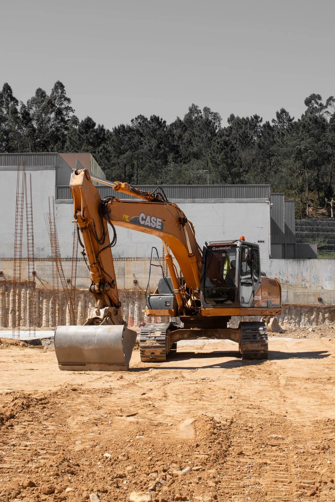 Excavadora en una obra de construcción con estructuras de hormigón
